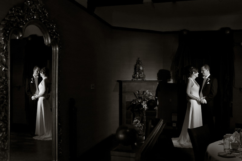 Bride and Groom holding hands with their reflection caught in the mirror