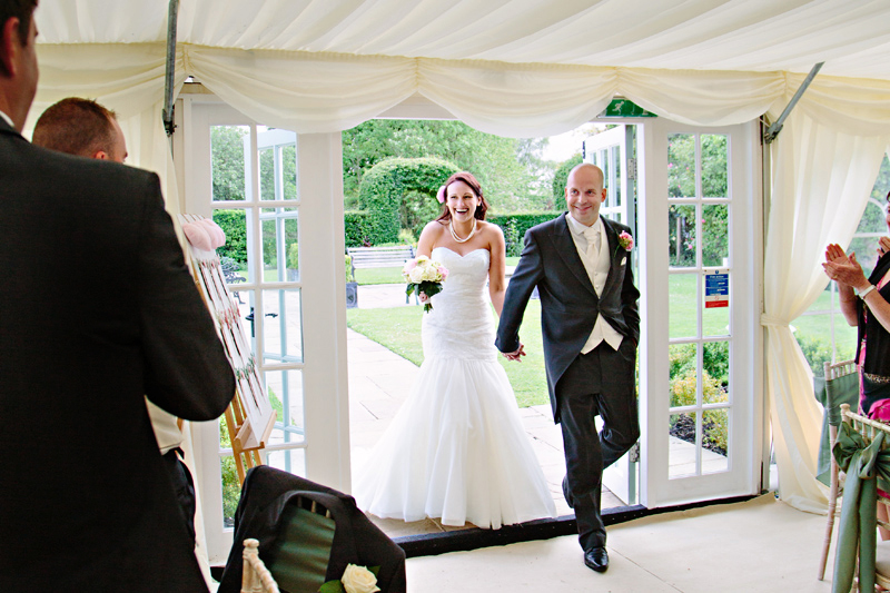 Guests clap the Bride and Groom as they enter the marquee