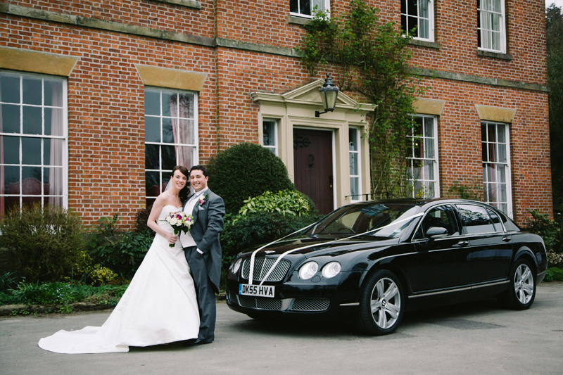 Bride and Groom with their wedding car on arrival at the venue