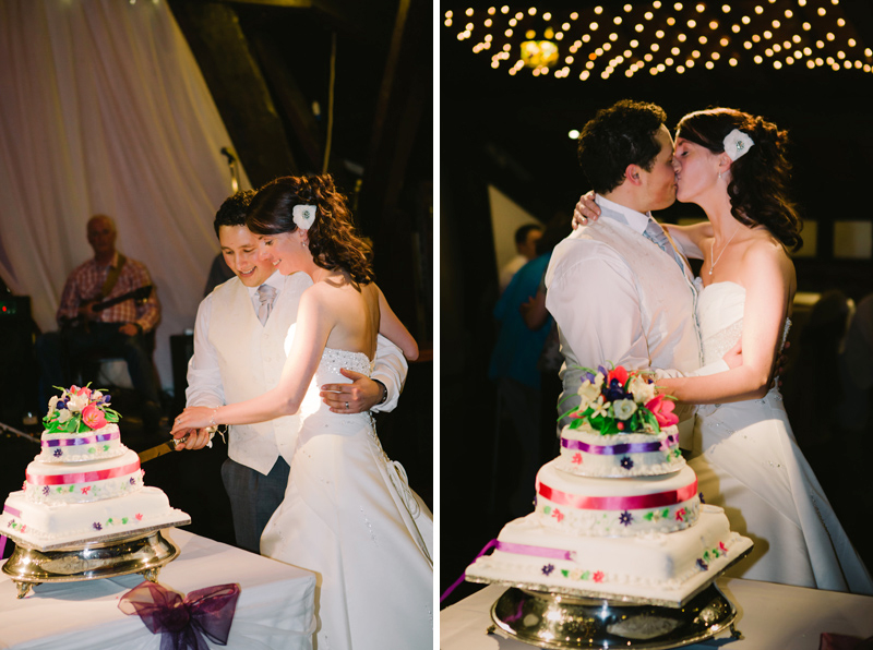 Bride and Groom cut their wedding cake in front of their guests